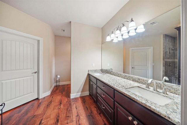 bathroom featuring a tile shower, vanity, and hardwood / wood-style flooring