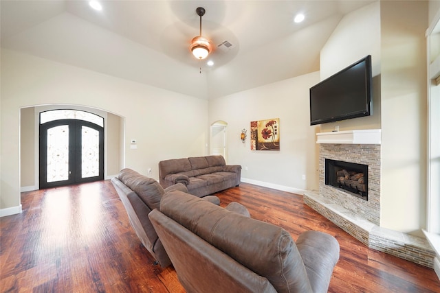 living room with ceiling fan, french doors, dark wood-type flooring, lofted ceiling, and a fireplace