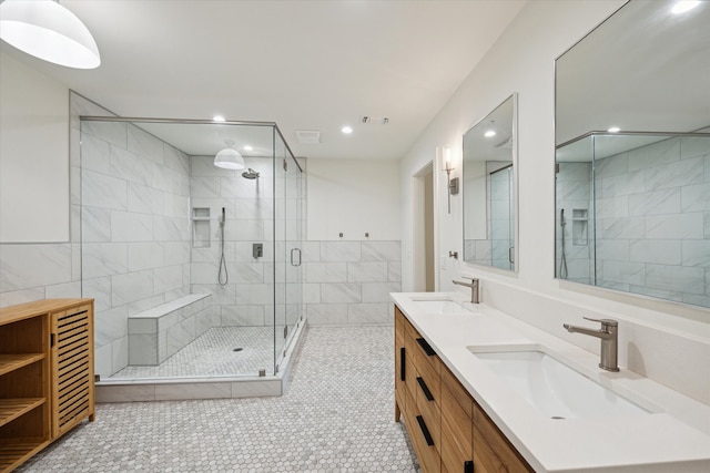 bathroom with vanity, walk in shower, tile patterned flooring, and tile walls