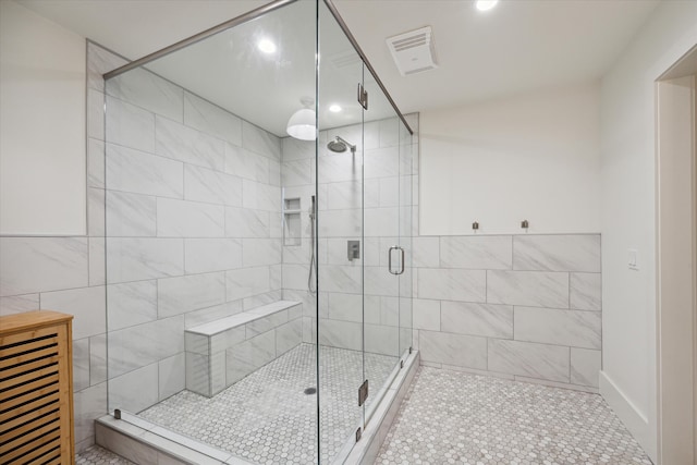 bathroom with a shower with door, tile patterned floors, and tile walls