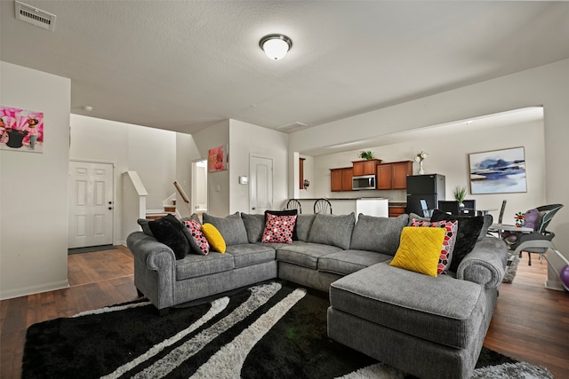 living room featuring dark hardwood / wood-style floors and a textured ceiling