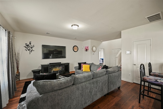 living room with dark hardwood / wood-style flooring and a fireplace