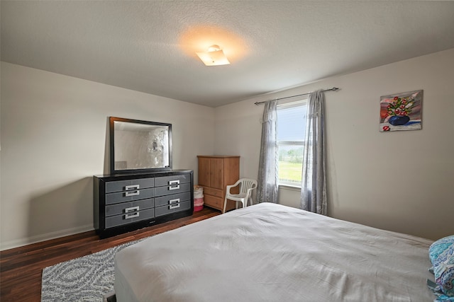 bedroom featuring dark hardwood / wood-style flooring and a textured ceiling