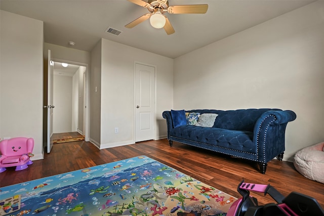 living area featuring dark hardwood / wood-style floors and ceiling fan