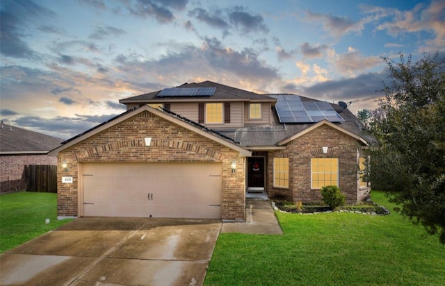 craftsman-style house with solar panels, a garage, and a yard