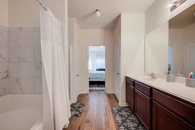 bathroom with wood-type flooring, vanity, and shower / bath combo