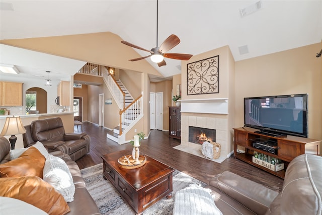 living room with a fireplace, dark hardwood / wood-style floors, vaulted ceiling, and ceiling fan