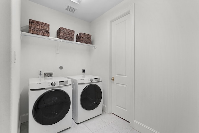 washroom with washer and dryer and light tile patterned floors