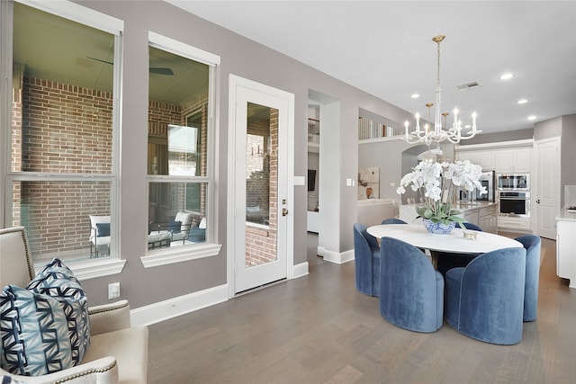 dining space with dark hardwood / wood-style floors, a healthy amount of sunlight, a chandelier, and sink