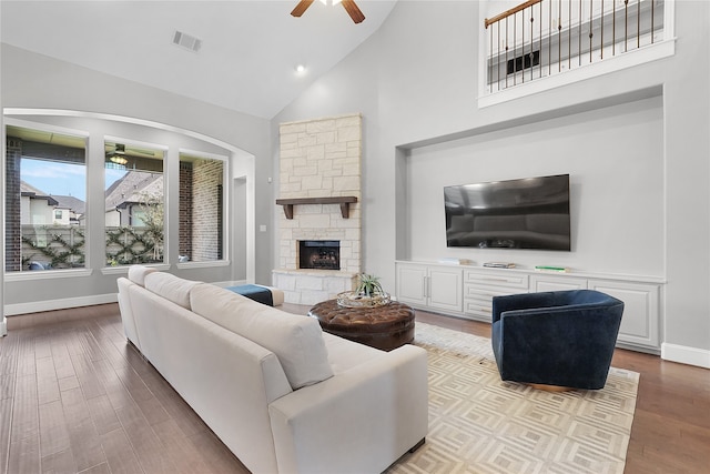 living room featuring light hardwood / wood-style floors, high vaulted ceiling, a fireplace, and ceiling fan