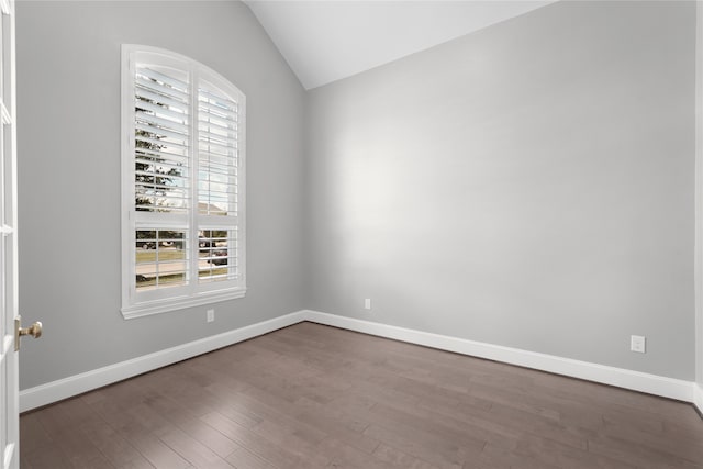 empty room with vaulted ceiling and hardwood / wood-style flooring