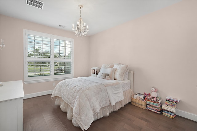 bedroom with dark hardwood / wood-style flooring and an inviting chandelier