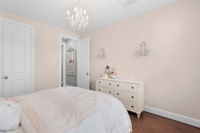 bedroom with an inviting chandelier and dark hardwood / wood-style floors