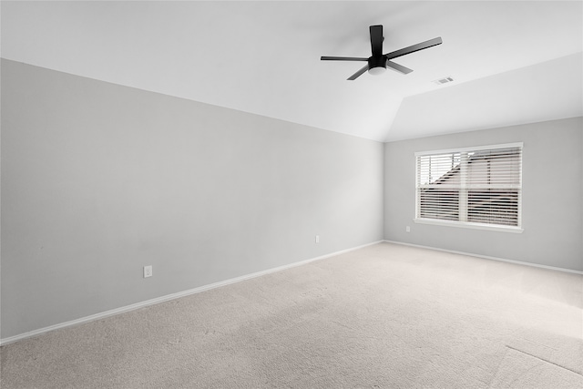 carpeted spare room featuring ceiling fan and vaulted ceiling