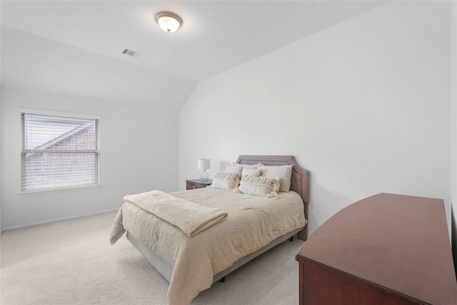 bedroom with vaulted ceiling and light colored carpet