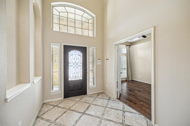 foyer entrance featuring light hardwood / wood-style flooring and a towering ceiling