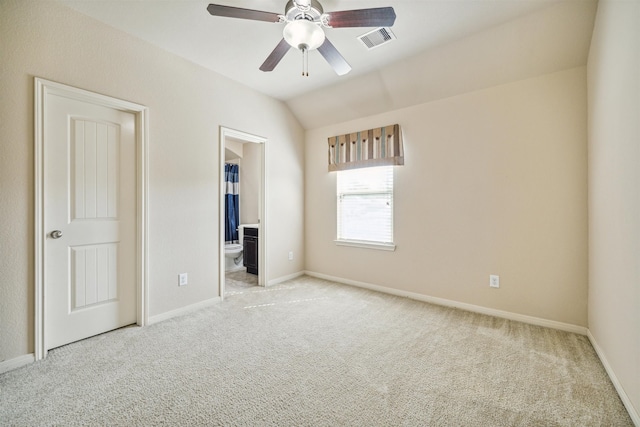 unfurnished bedroom with ensuite bath, ceiling fan, light colored carpet, and lofted ceiling