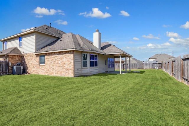 rear view of house featuring central AC unit, a patio area, and a lawn