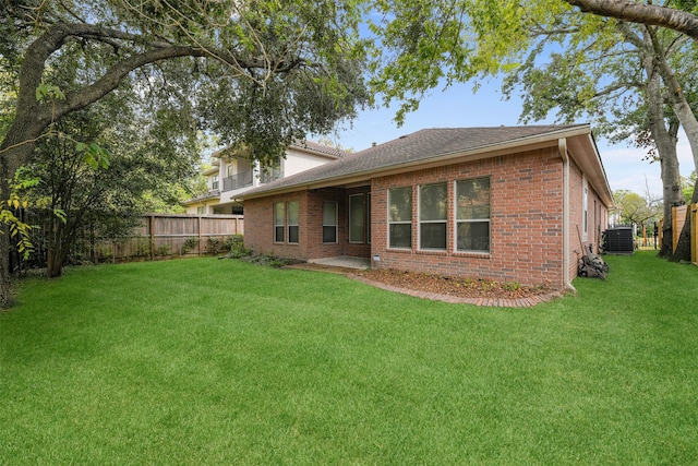 back of house featuring a lawn and central AC