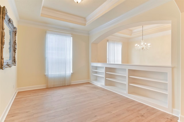 spare room with hardwood / wood-style floors, a tray ceiling, and crown molding