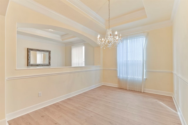 unfurnished room with a raised ceiling, a wealth of natural light, and ornamental molding