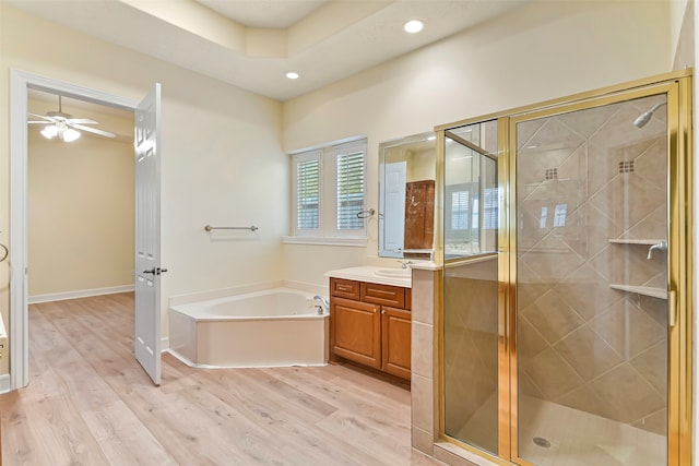 bathroom with shower with separate bathtub, vanity, hardwood / wood-style flooring, and ceiling fan