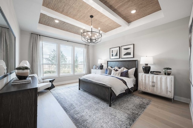 bedroom with a raised ceiling, wooden ceiling, light hardwood / wood-style flooring, and an inviting chandelier