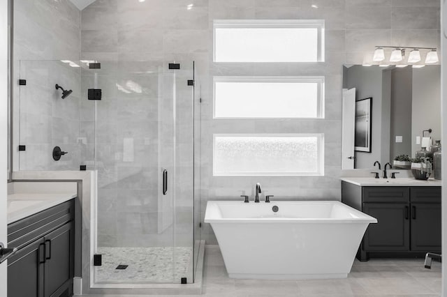 bathroom with vanity, tile walls, shower with separate bathtub, and tile patterned flooring