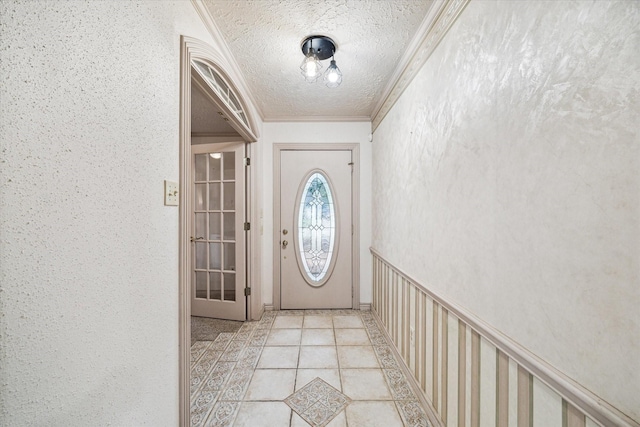 doorway with light tile patterned floors, a textured ceiling, and crown molding