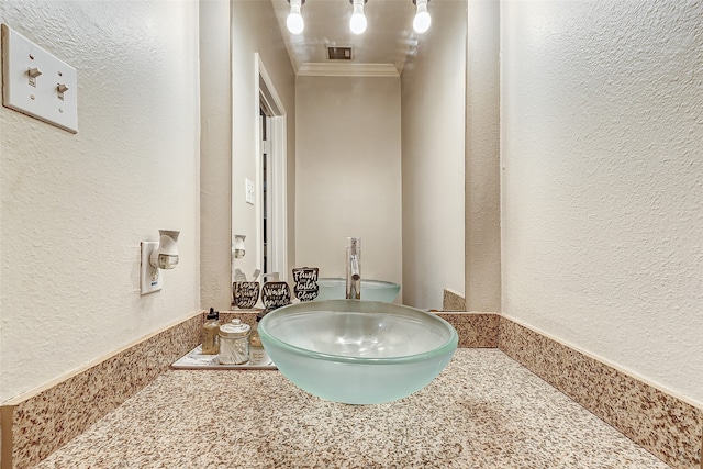 bathroom with ornamental molding and sink