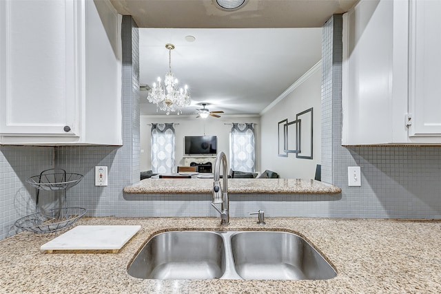 kitchen featuring crown molding, white cabinetry, tasteful backsplash, and sink