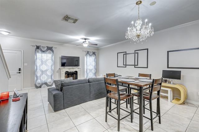 tiled dining room featuring ornamental molding and ceiling fan with notable chandelier