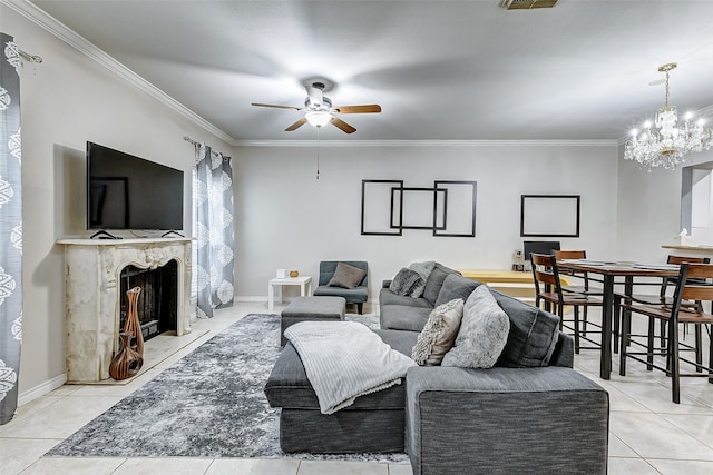 living room with crown molding, a premium fireplace, light tile patterned floors, and ceiling fan with notable chandelier