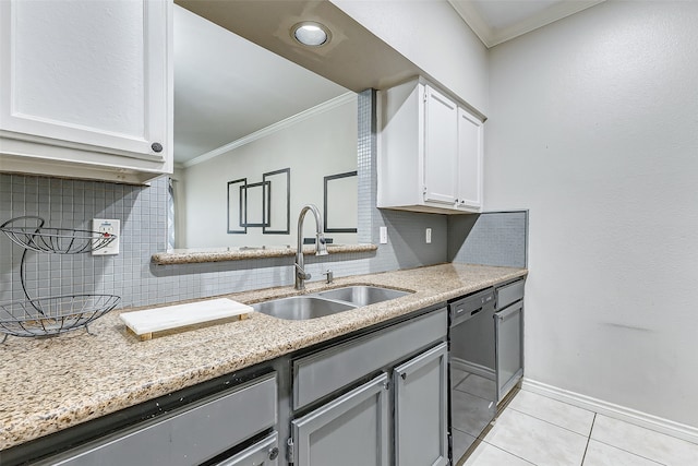 kitchen featuring black dishwasher, tasteful backsplash, sink, white cabinets, and light tile patterned floors