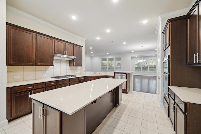 kitchen featuring ornamental molding, hanging light fixtures, a notable chandelier, dark brown cabinets, and kitchen peninsula