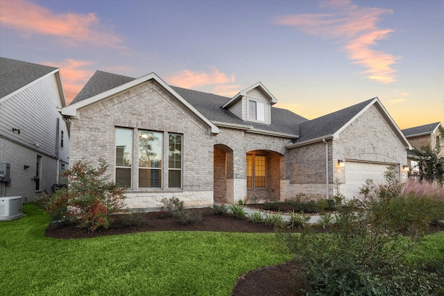 french country style house featuring a yard and a garage