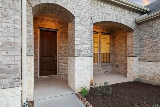 exterior entry at dusk featuring a porch