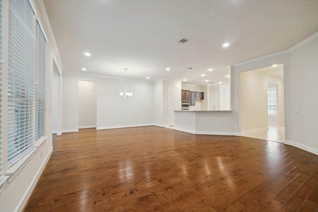 unfurnished living room with ornamental molding, a chandelier, and dark hardwood / wood-style flooring