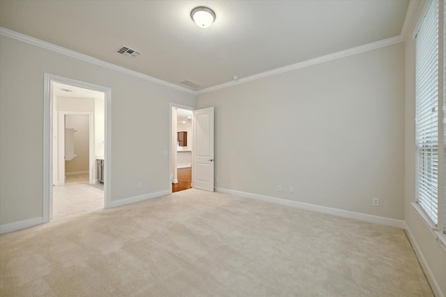 unfurnished bedroom with ornamental molding, multiple windows, ensuite bathroom, and light carpet