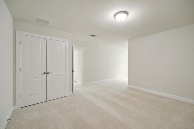 carpeted empty room featuring a textured ceiling