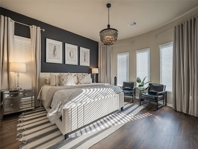 bedroom featuring a chandelier and dark hardwood / wood-style flooring