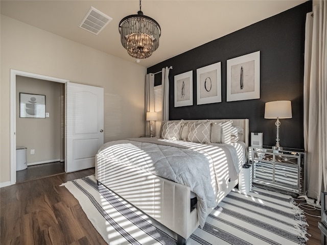 bedroom with an inviting chandelier and dark wood-type flooring