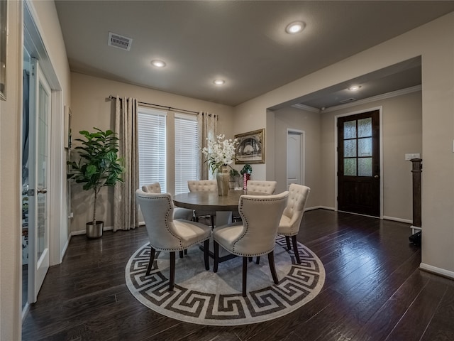 dining area with dark wood-type flooring, ornamental molding, and french doors