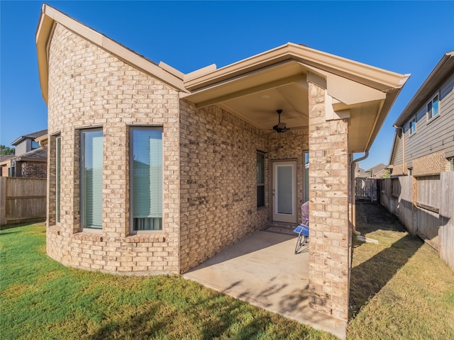 property entrance with a patio, a yard, and ceiling fan