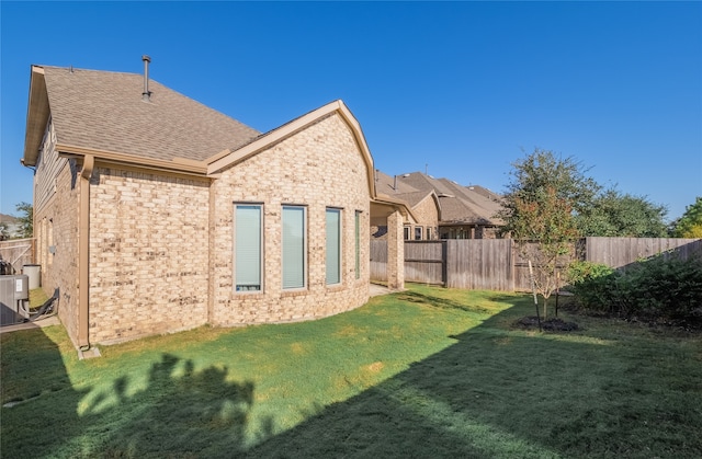 back of house featuring central AC and a lawn