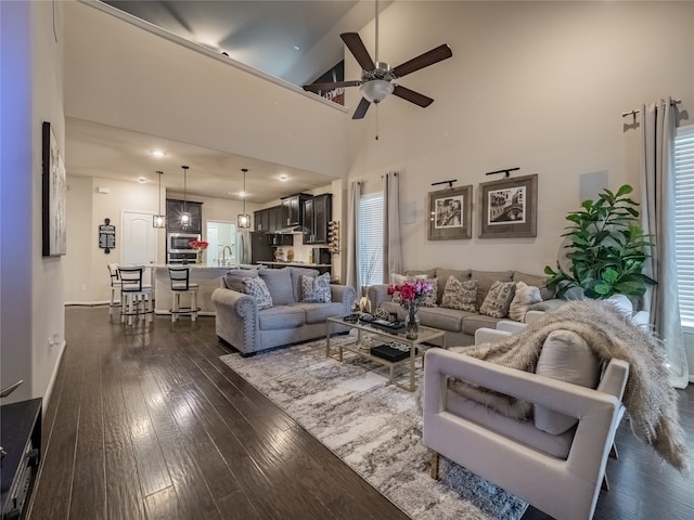 living room featuring dark wood-type flooring, ceiling fan, and high vaulted ceiling