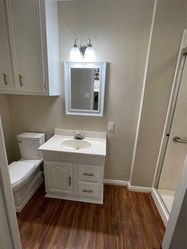 bathroom with vanity, wood-type flooring, and toilet