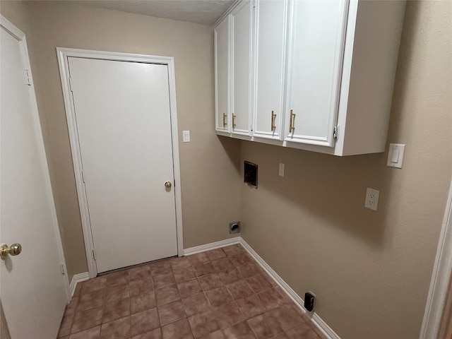 laundry area with electric dryer hookup and cabinets