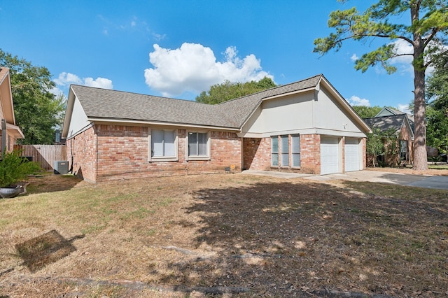 view of front of property featuring central AC, a garage, and a front yard