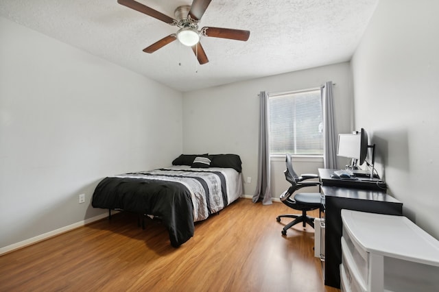 bedroom with light hardwood / wood-style flooring, a textured ceiling, and ceiling fan